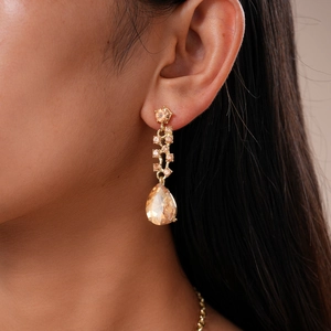 Macro view of teardrop champagne gemstone earrings with elegant gold setting
