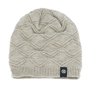 Detailed view of the wave knit texture and H logo label on a thick winter beanie hat