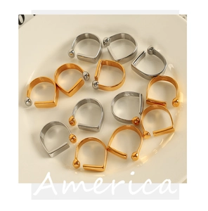 Close-up of gold and silver U-shaped metal ear clips on a white ceramic plate