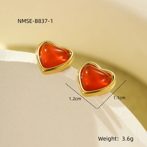 Macro shot of red heart stud earrings with gold trim and textured red agate finish