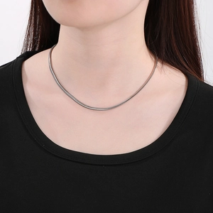 Close-up of sleek silver flat snake chain necklace on model for minimalist style