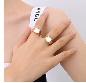 Close-up of vintage 18k gold square ring with white shell inlay on model's hand