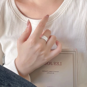 Detailed view of sterling silver ring with irregular hammered texture on a hand