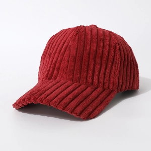 Detail of red corduroy baseball cap showing soft ribbed texture and curved brim