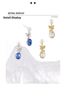 Detail view of pearl pineapple earrings with blue and clear zircon stones in silver and gold