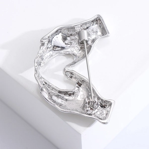 Close-up of the silver metal brooch back showing the secure pin clasp and textured finish