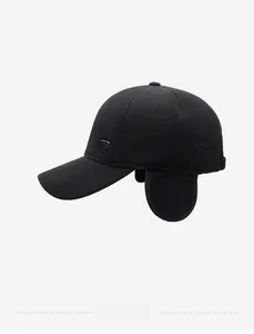 Macro detail of black knitted baseball cap with ear flaps and metal triangle emblem