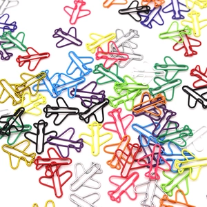 Close-up of colorful airplane shaped paper clips in metallic finish on white background