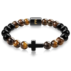Macro detail of tiger eye bead bracelet with cross charm and golden letter E bead