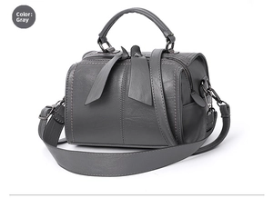 Detailansicht der grauen Lederhandtasche mit einzigartigen blattförmigen Reißverschlüssen