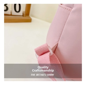Detailed close-up of pink children backpack showing reinforced stitching and plastic buckle