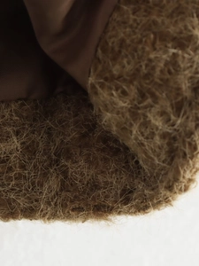 Close-up of brown plush fabric with smooth inner lining and detailed fiber texture