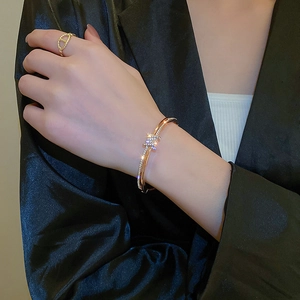 Detailed view of rose gold bracelet and ring with sparkling zircon inlays on model