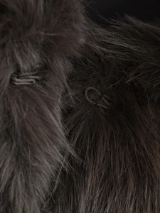 Detailed macro view of the dark brown faux fur texture and hidden metal hook fastener