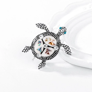 Vintage silver turtle brooch with colorful shell inlay and blue rhinestone eyes
