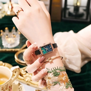 Close-up of elegant ladies square green dial watch with rose gold case and black leather strap