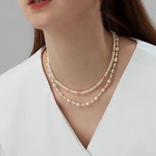 Close-up of double-layer natural pearl necklace with gold accents on female model neck