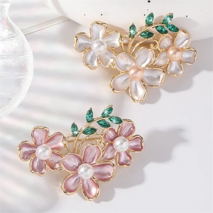 Elegant gold flower brooch with enamel petals, pearls, and green crystals for women