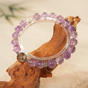 Detailed macro view of purple amethyst beads and engraved silver spacer on a crystal bracelet