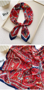 Detail of red square silk scarf with navy borders and vintage equestrian print patterns