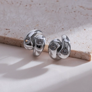 Detail of silver double-layered swirl earrings featuring clear zircon stone inlays