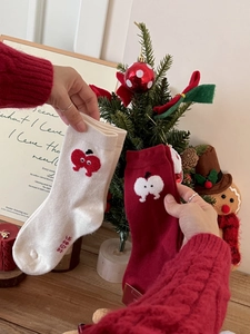 Close-up of thick Christmas knit socks with embroidered apple and heart patterns