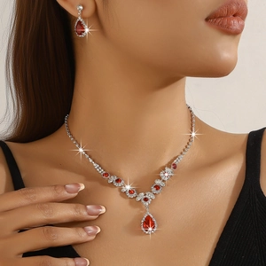 Detailed view of teardrop red gemstone bridal necklace and matching earrings set on model