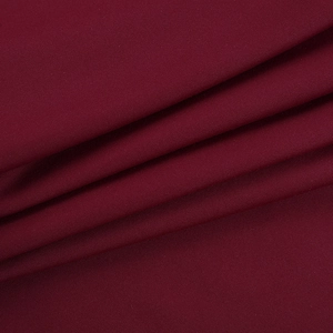 Détail macro du tissu en maille élastique bordeaux montrant une texture douce