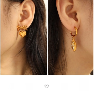 Macro detail of vintage gold heart and leaf drop earrings with sparkling zircon inlay