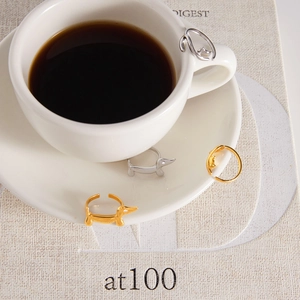 Macro detail of adjustable dachshund dog rings in gold and silver with zircon eyes