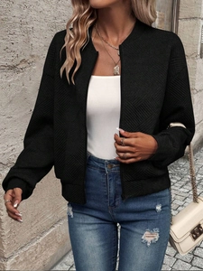 Close-up of black quilted bomber jacket texture with zip-up design and ribbed collar