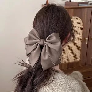 Elegant large brown satin bow banana hair clip for high ponytail styling on women