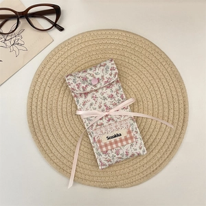 Floral fabric eyewear pouch with pink ribbon bow and lace detail on a straw mat background