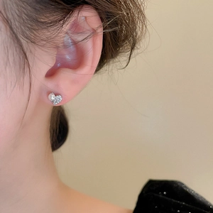 Close-up of minimalist heart stud earring with pearl and cubic zirconia on a model