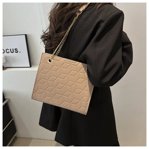 Close-up of khaki geometric 3D embossed tote bag with elegant gold chain shoulder strap