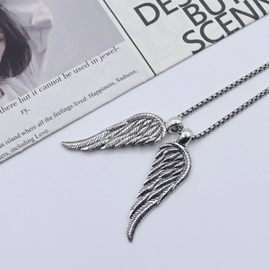 Punk style silver angel wings pendant necklace with box chain on vintage background