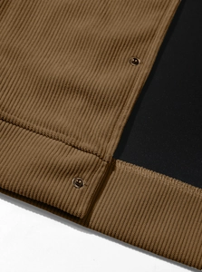 Macro shot of brown corduroy fabric detailing with vintage metal buttons on a men's jacket
