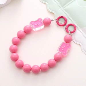 Detailed view of pink acrylic bear beads and metal ring clasps for phone or bag strap