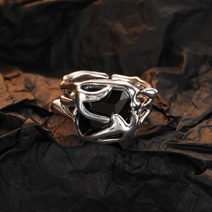 Detail view of vintage multi-layer silver ring with square black zircon on dark paper