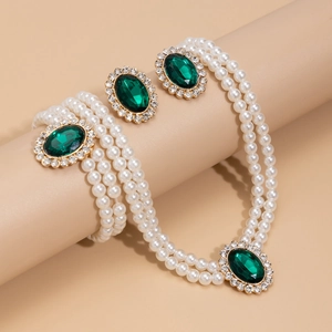 Detail of vintage 3-piece multi-layer pearl jewelry set with green gemstone accents