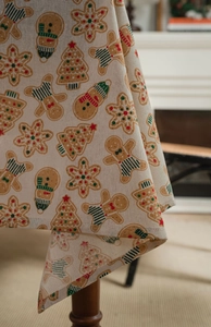 Close-up of linen Christmas tablecloth corner with gingerbread and tree prints