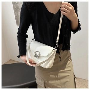 Detail showing white leather bag with a stylish silver butterfly-shaped metal buckle clasp