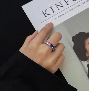 Detailed shot of alternating blue and purple gems set in a gold-plated silver ring