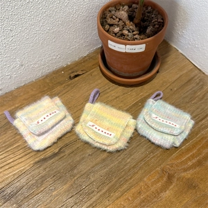 Detail view of colorful crochet plush earphone cases in pink, yellow and green colors