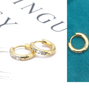 Detailed view of gold stainless steel huggie earrings with pavé cubic zirconia inlay
