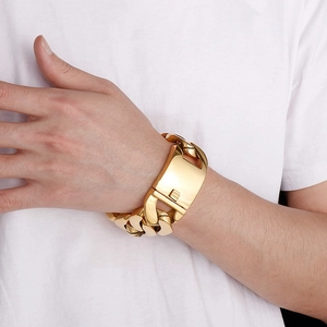 Detail of heavy gold Cuban link bracelet with large square push-pull clasp on wrist