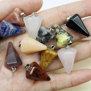 Natural crystal cone pendants in various stones held in hand showing hexagonal design