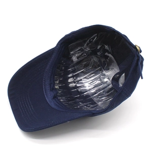 Detail view of navy cotton cap showing internal plastic support and adjustable metal buckle