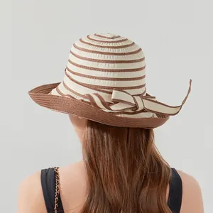 Women's summer straw sun hat with striped pattern and elegant bow for beach travel