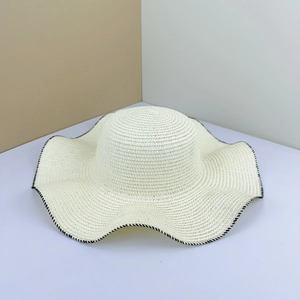 Wavy brim straw sun hat in cream white with black stitched edges for summer beach vacation